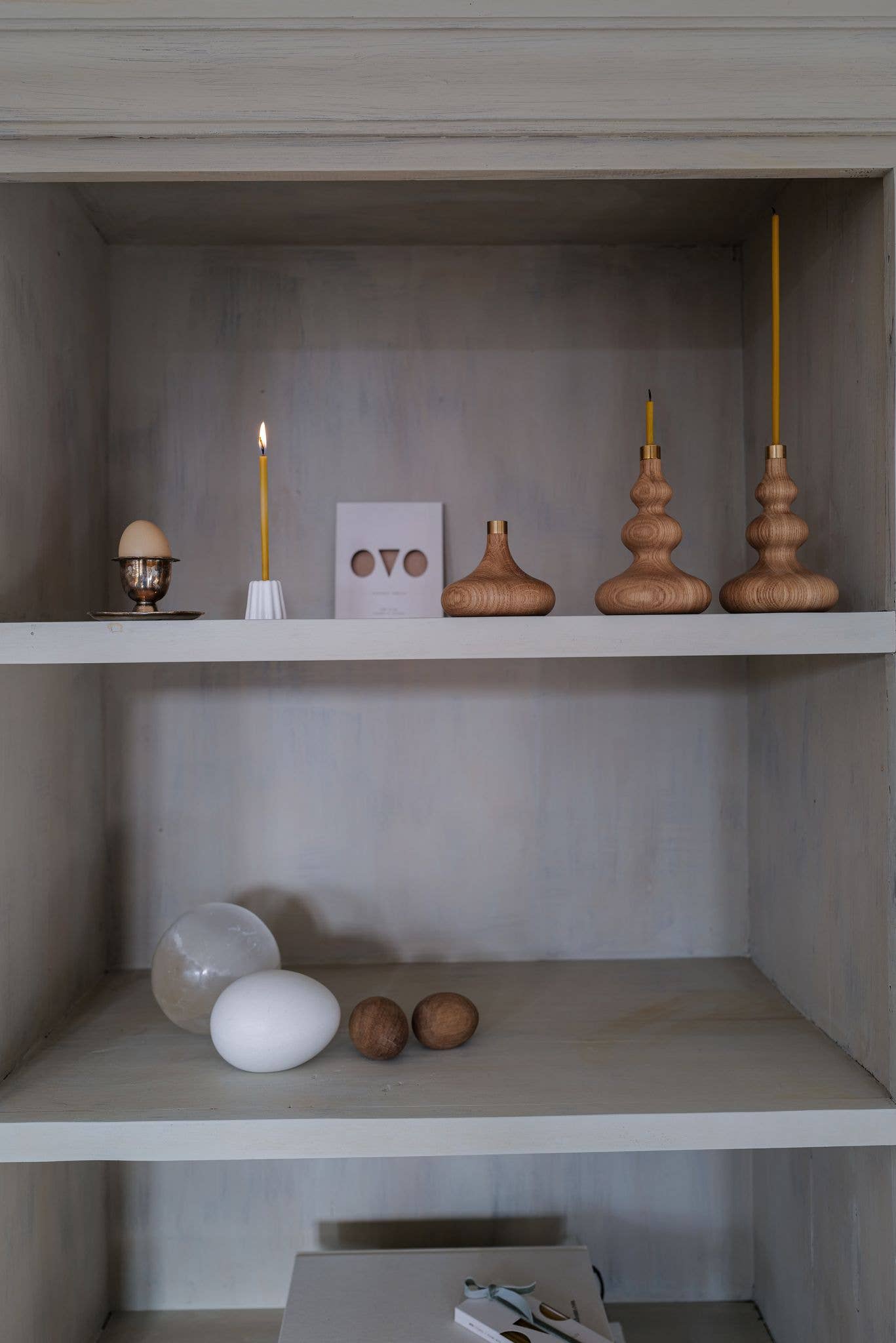 Olika ljusstakar i en bokhylla