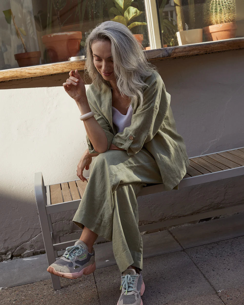 Modellen har på sig en grön kimono och gröna linnebyxor