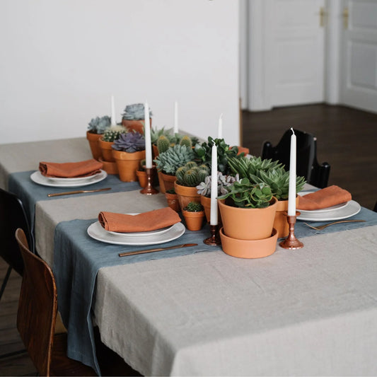 Ett dukat bord med textilier i materialet lin.