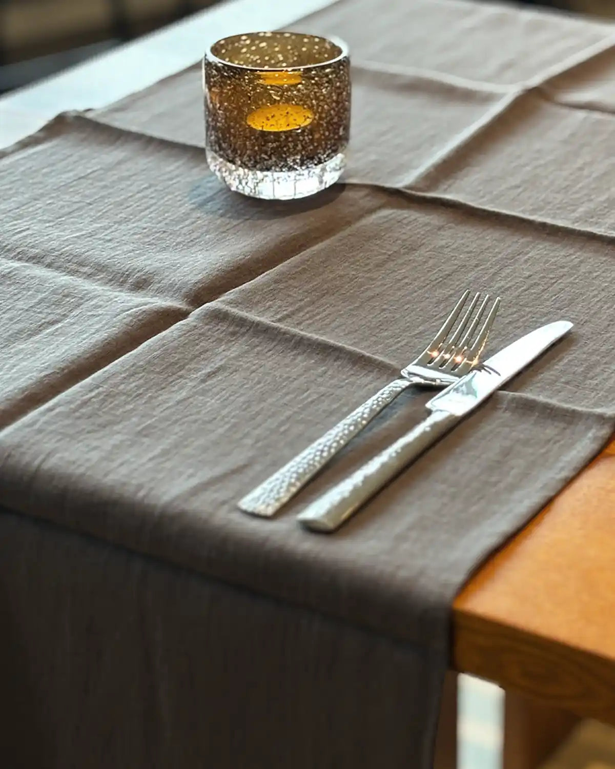 En köksbord med en mörkgrå löpare i linnetyg