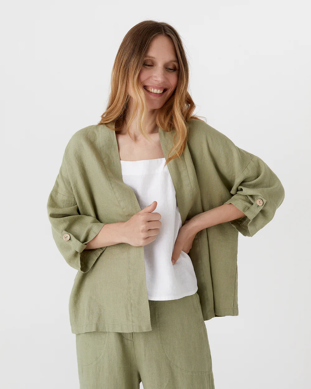 Salviagrön kimono med uppvikta armar och knappar i ärmsluten.