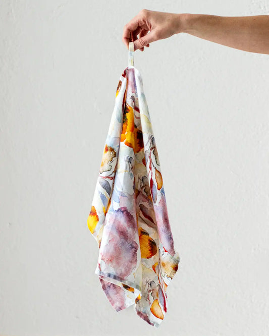 En kökshandduk med abstrakt mönster i orange och röd nyans