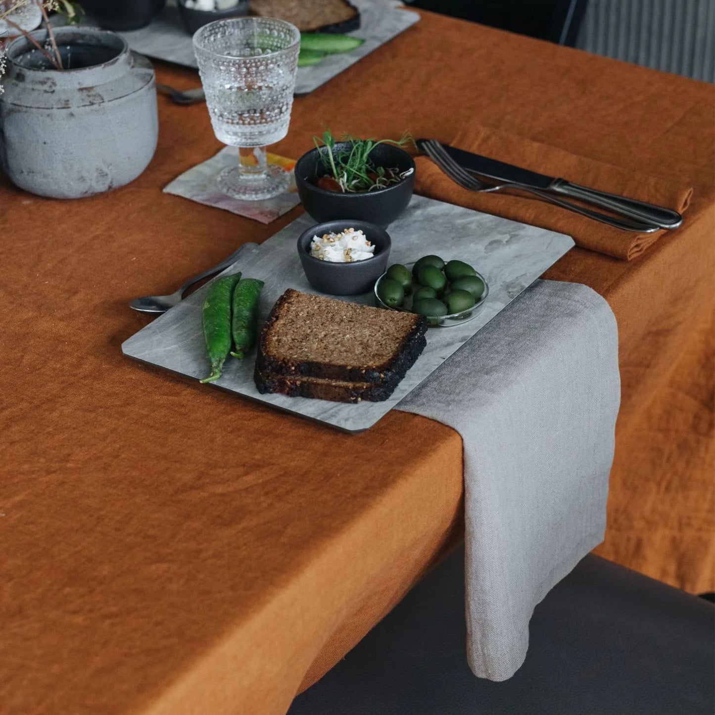 Ett dukat bord med orange och gåra linnetextilier