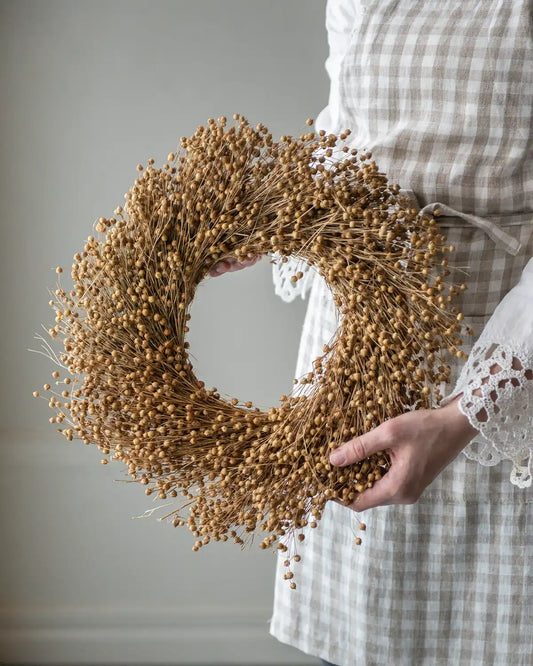 Person håller i en linkrans och har på sig ett rutigt förkläde