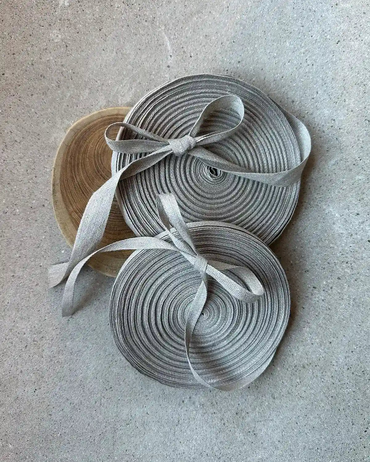 Stora rullar av linneband i naturell färg.