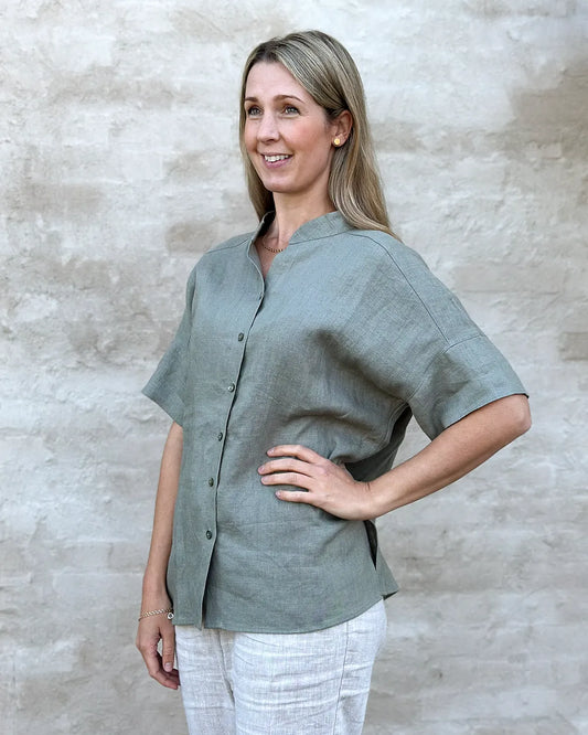 Kortärmad linneblus i grönt med farfarskrage och knappar fram.
