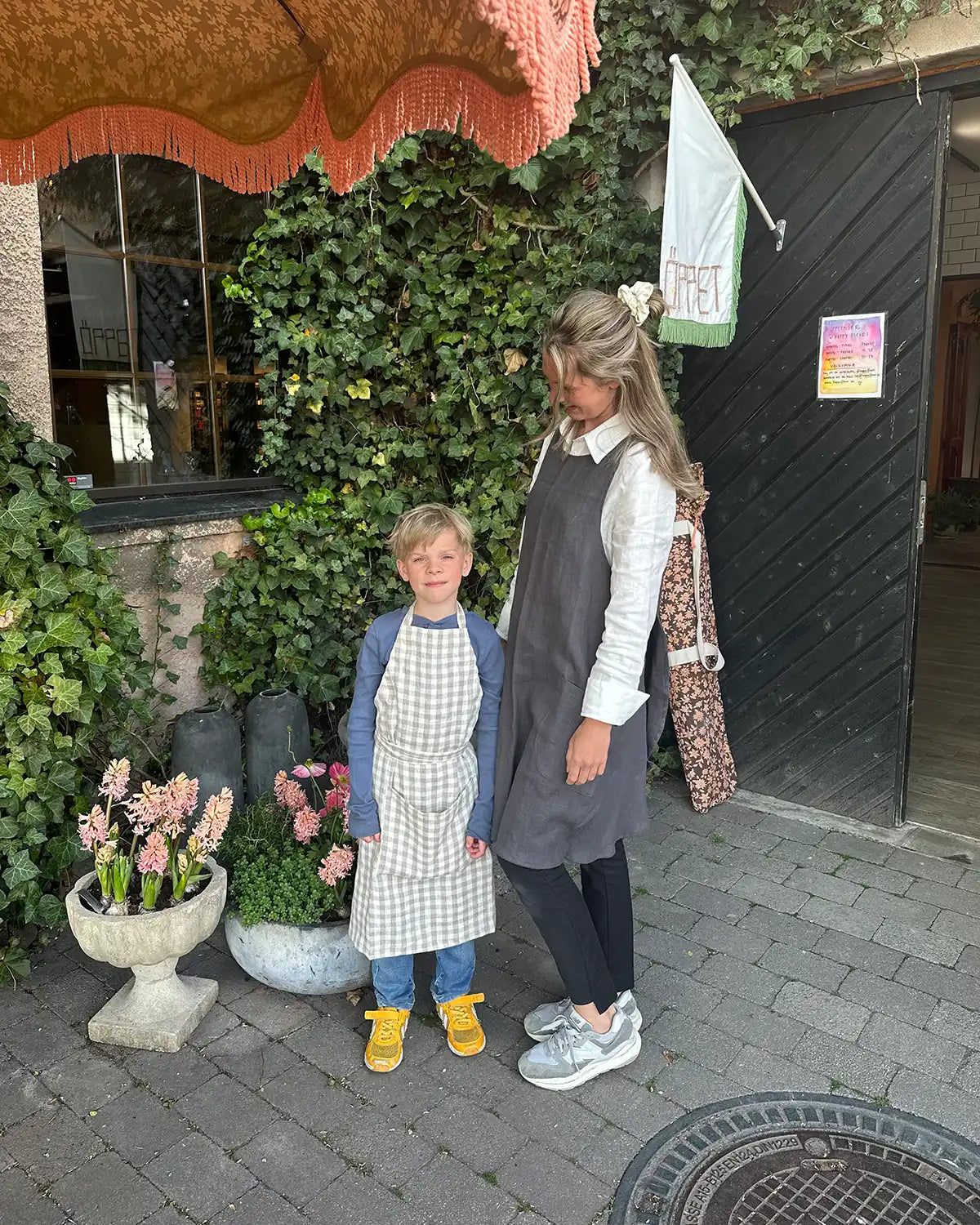 En vuxen och ett barn har på sig linneförkläde.