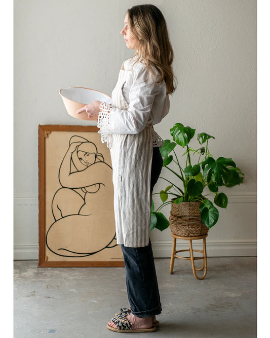 En dam bär ett köksförkläde med ränder