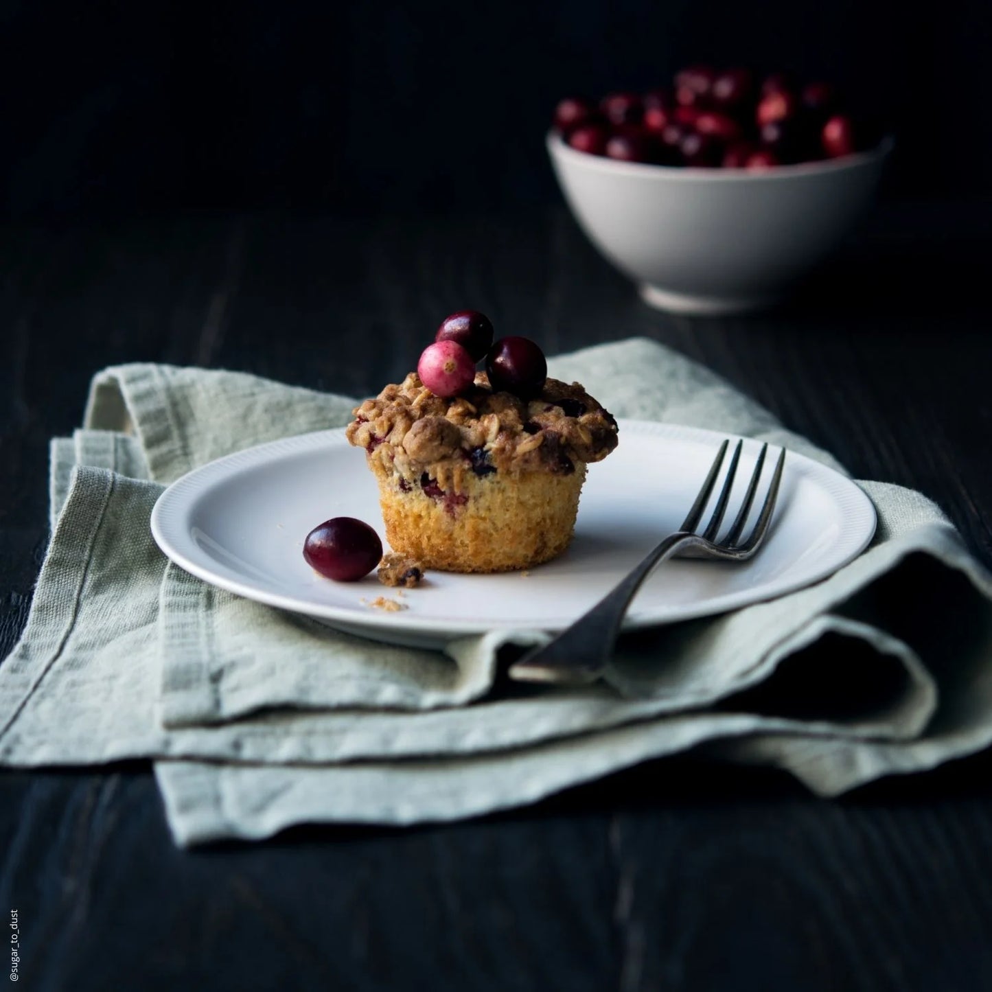 En bakelse på ett fat tillsammans med linneprodukter.