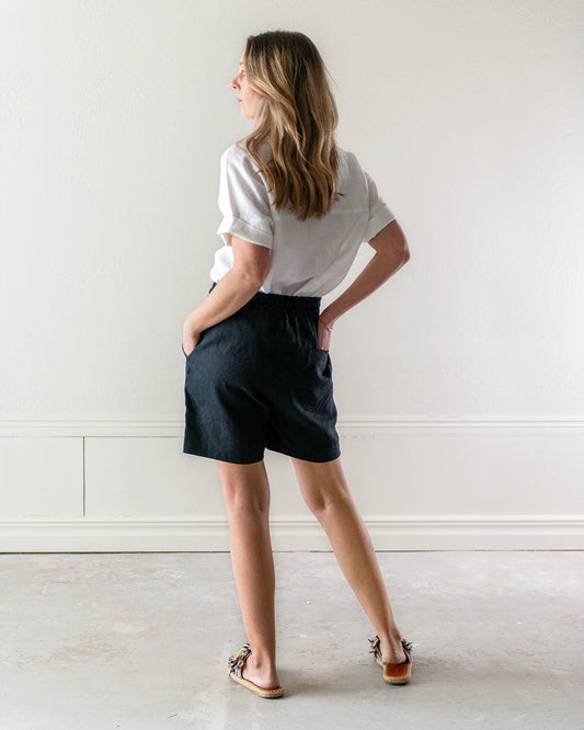 Svarta linneshorts och vit kortärmad linneblus