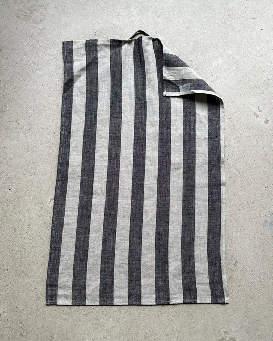 En handduk till köket med breda ränder i svart och beiget.