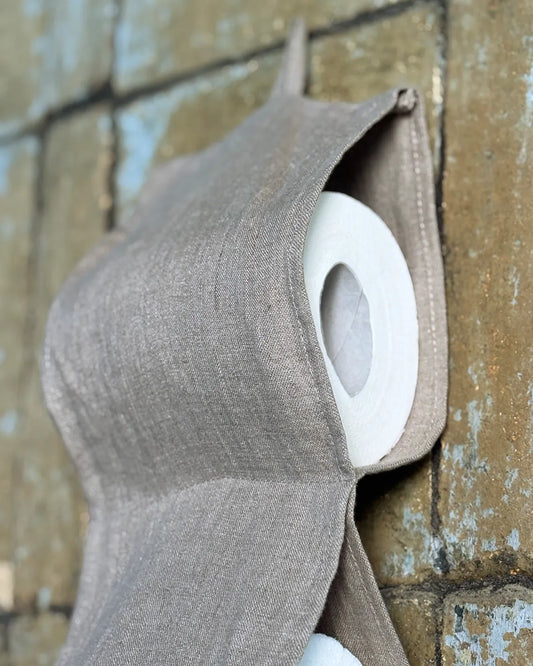 En beige linnehållare till toarullarna