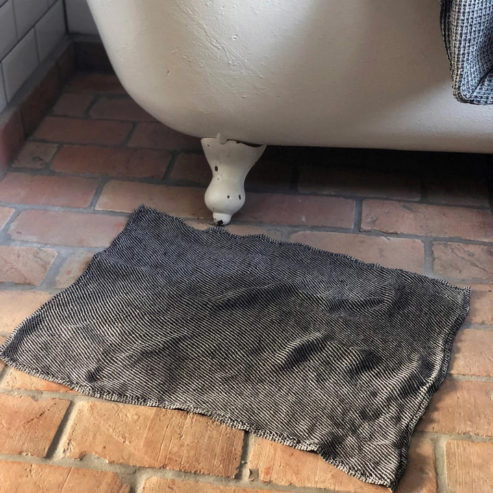 En svart badrumsmatta i linne