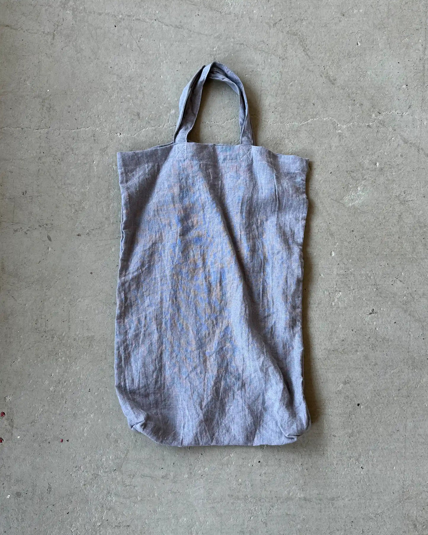 En grå tygväska med korta handtag