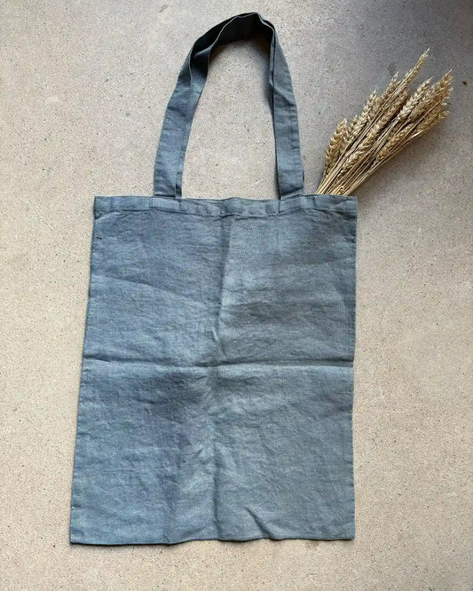 En tygväska med långa handtag i blågrå.