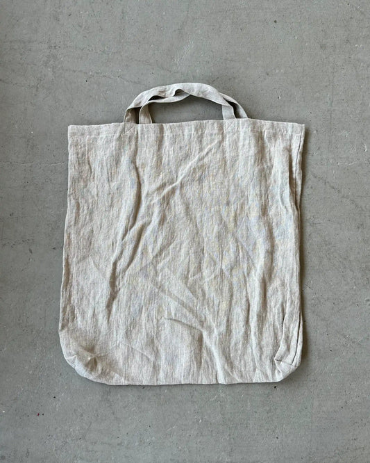 Tygpåse av linne ligger på betonggolv