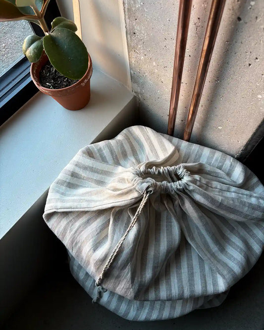 En stor linnetygpåse med vita och beiga ränder.