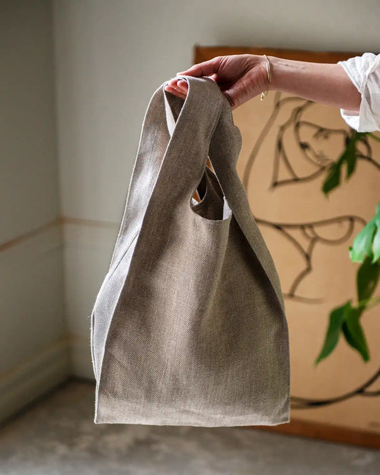 En vetefärgad tygpåse i linne med korta handtag