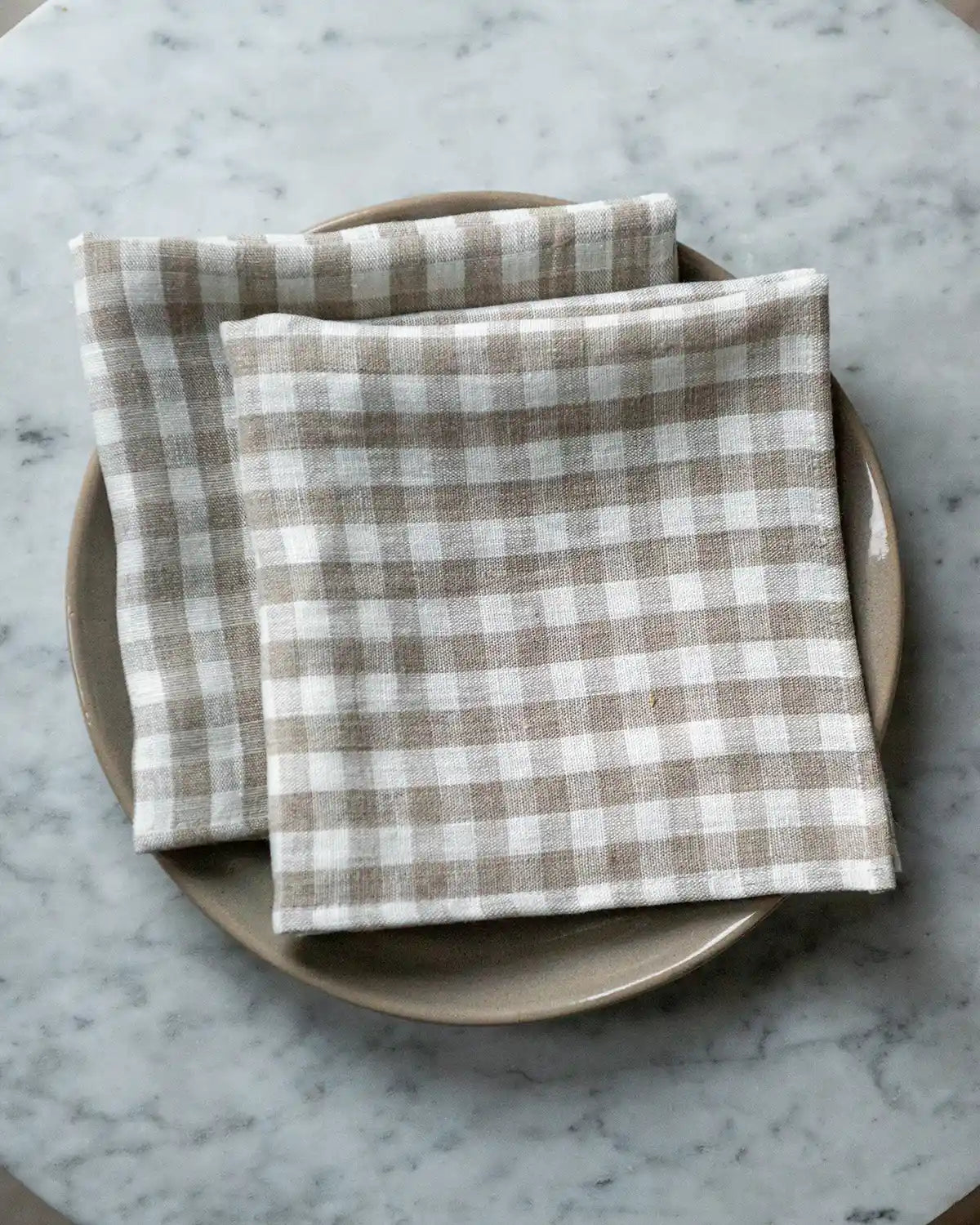 Rutiga linneservetter i vit och beige.