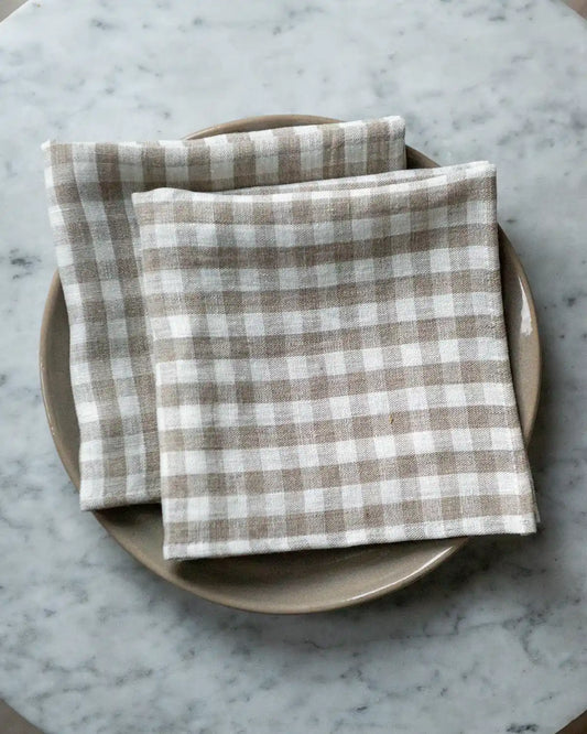 Rutiga linneservetter i vit och beige.