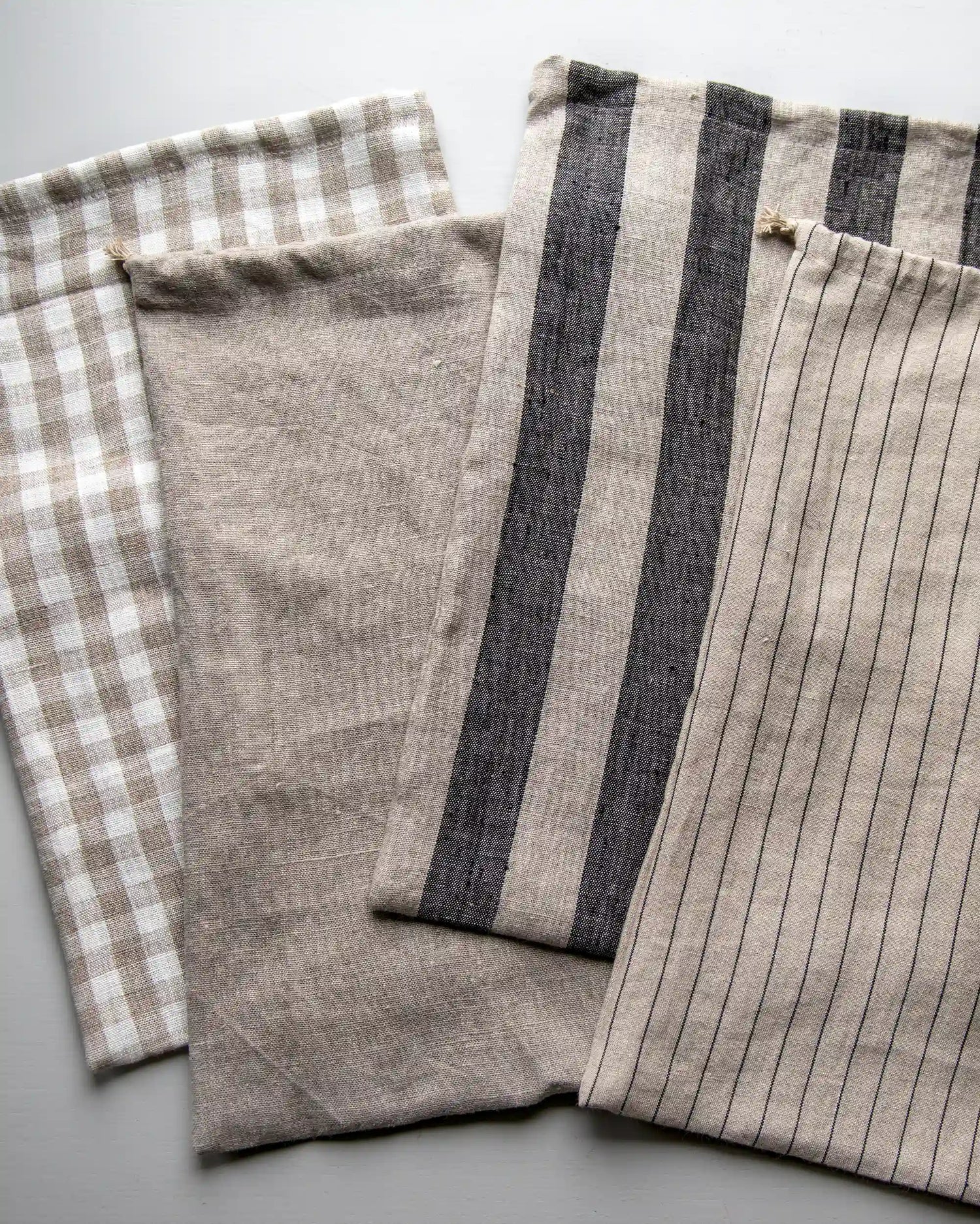 Fyra stycken rektangulära brödpåsar i linne. Alla påsar är i olika färger och mönster.  