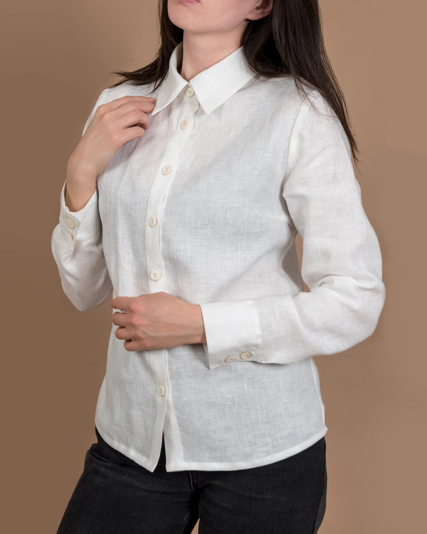 En tjej har på sig en tidlös och handsydd vit linneskjorta. 