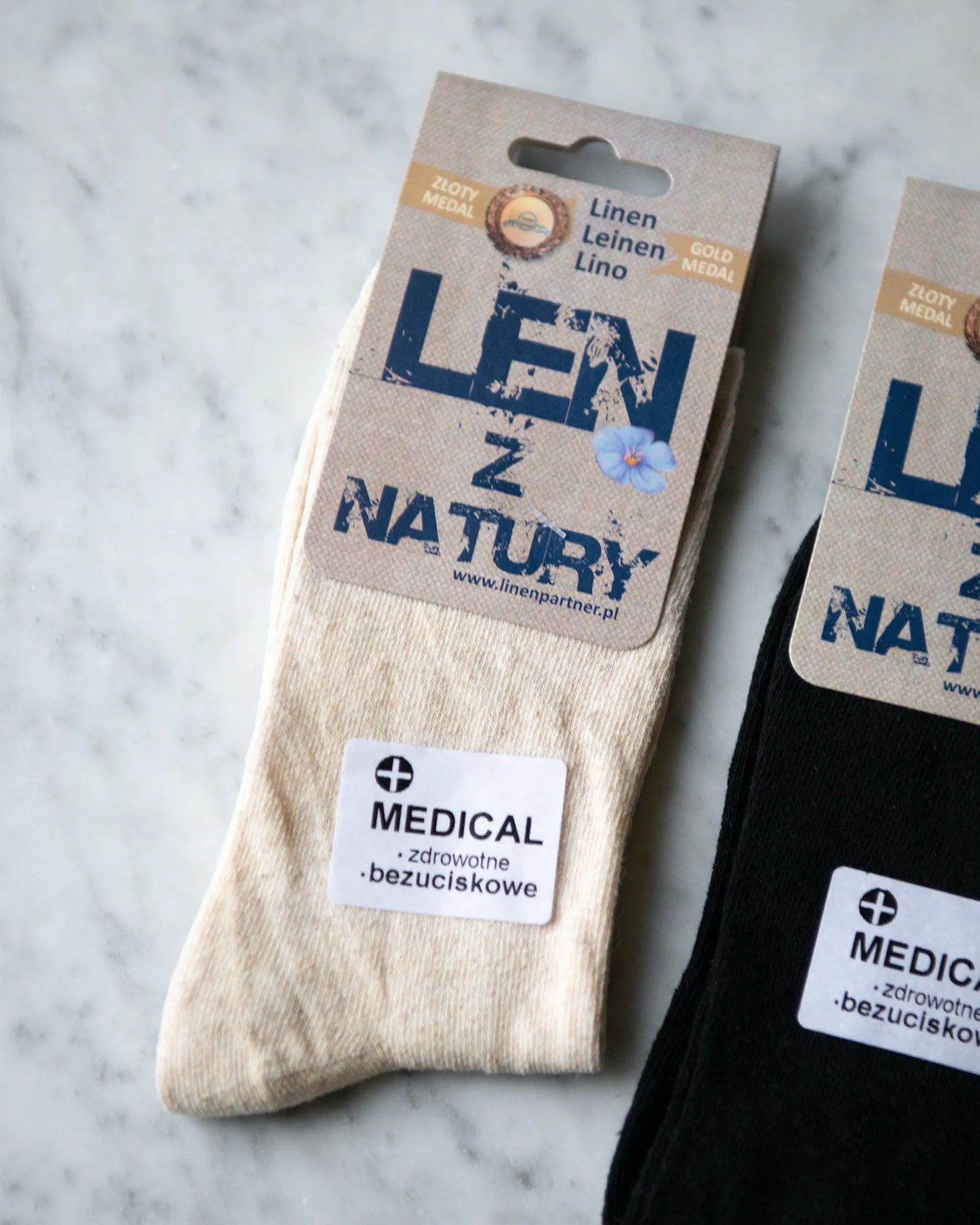 Ett par handsydda beiga och svarta strumpor i linne.