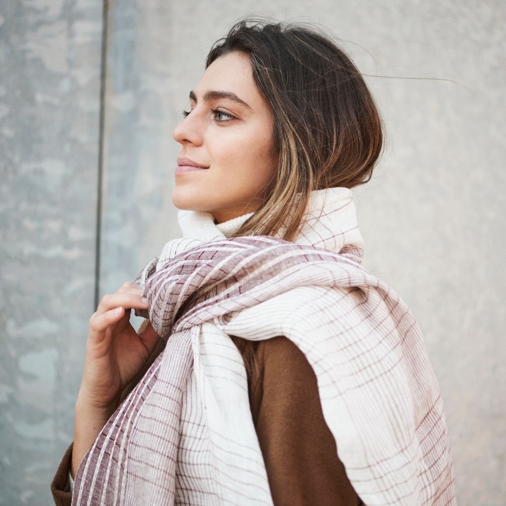 Kvinna bär en handvävd linne scarf runt halsen .
