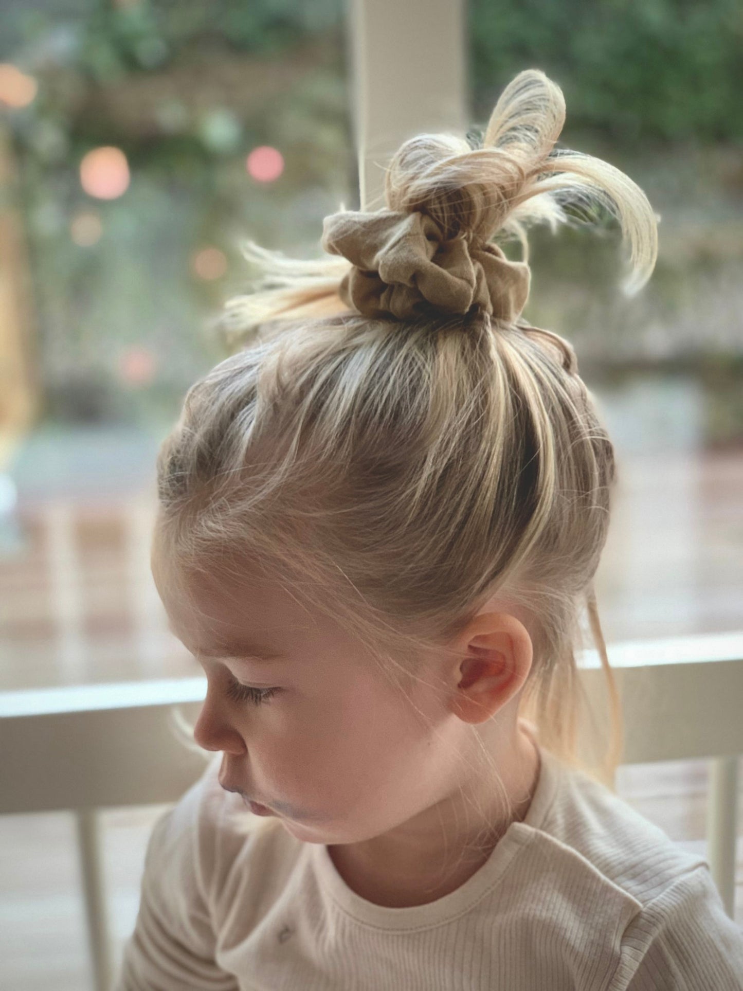 Flicka bär en handsydd beige scrunchie i lin.