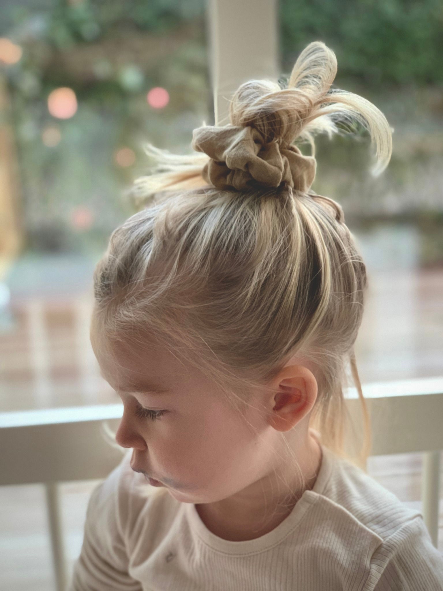 Flicka bär en handsydd beige scrunchie i lin.