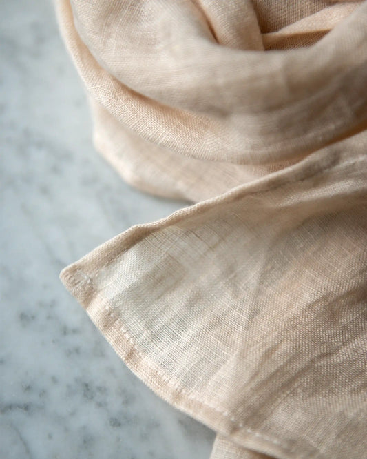 Handsydd linnehalsduk i beige.