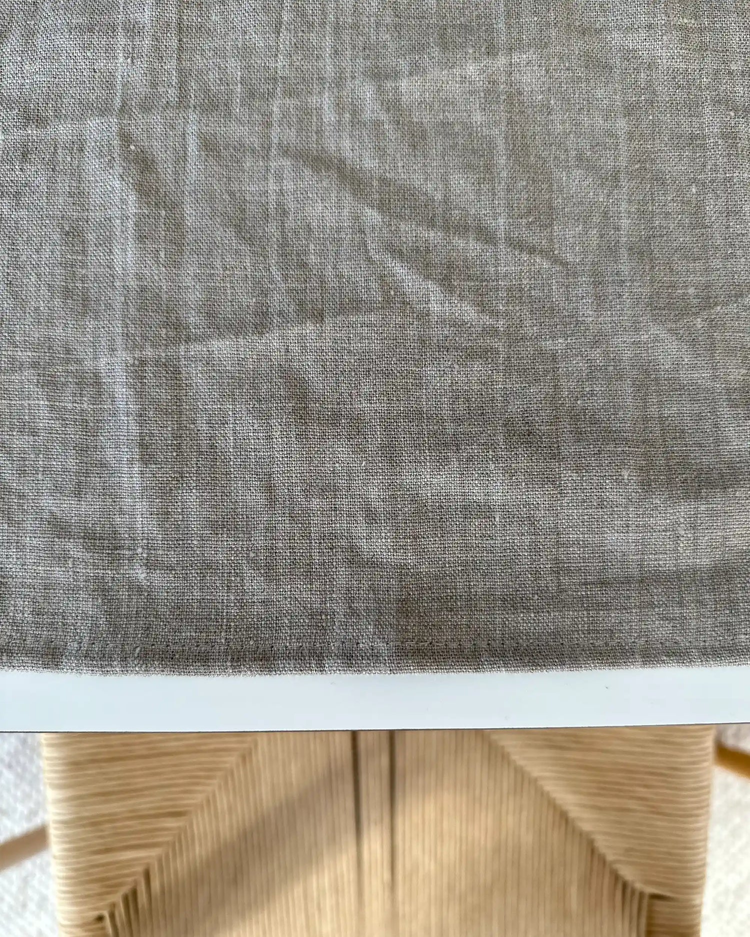 En handsydd kvadratiskt bordstablett i stentvättat linne. 