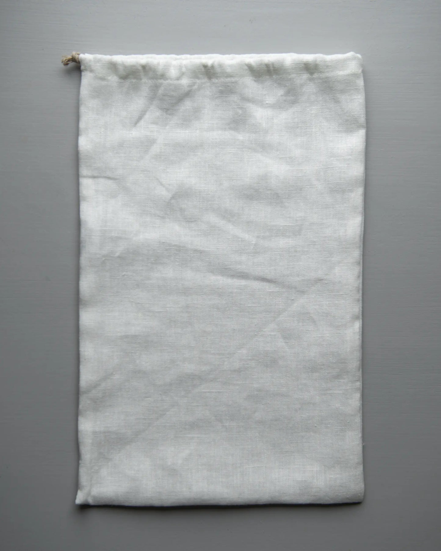 Handsydd brödpåse i vitt linnetyg.