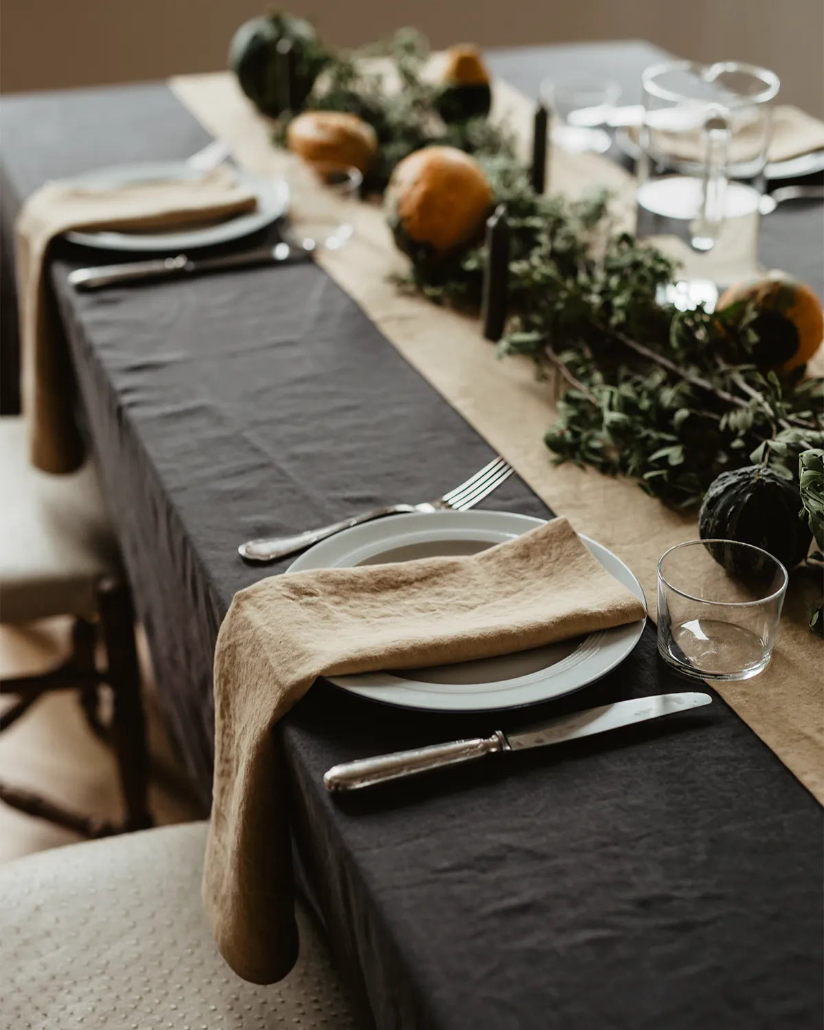 Ett dukat bord med en mörkgrå rektangulär linneduk. 
