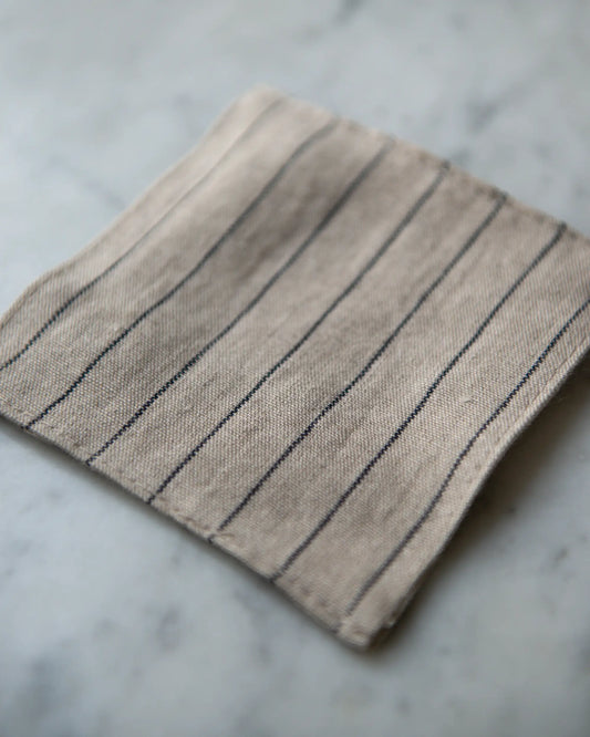 Glasunderlägg i randigt linne.