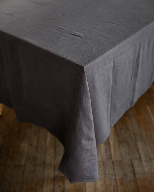 En mörkgrå duk i linne ligger på ett bord. 