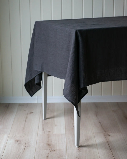 En handsydd rektangulär mörkgrå duk i linne.