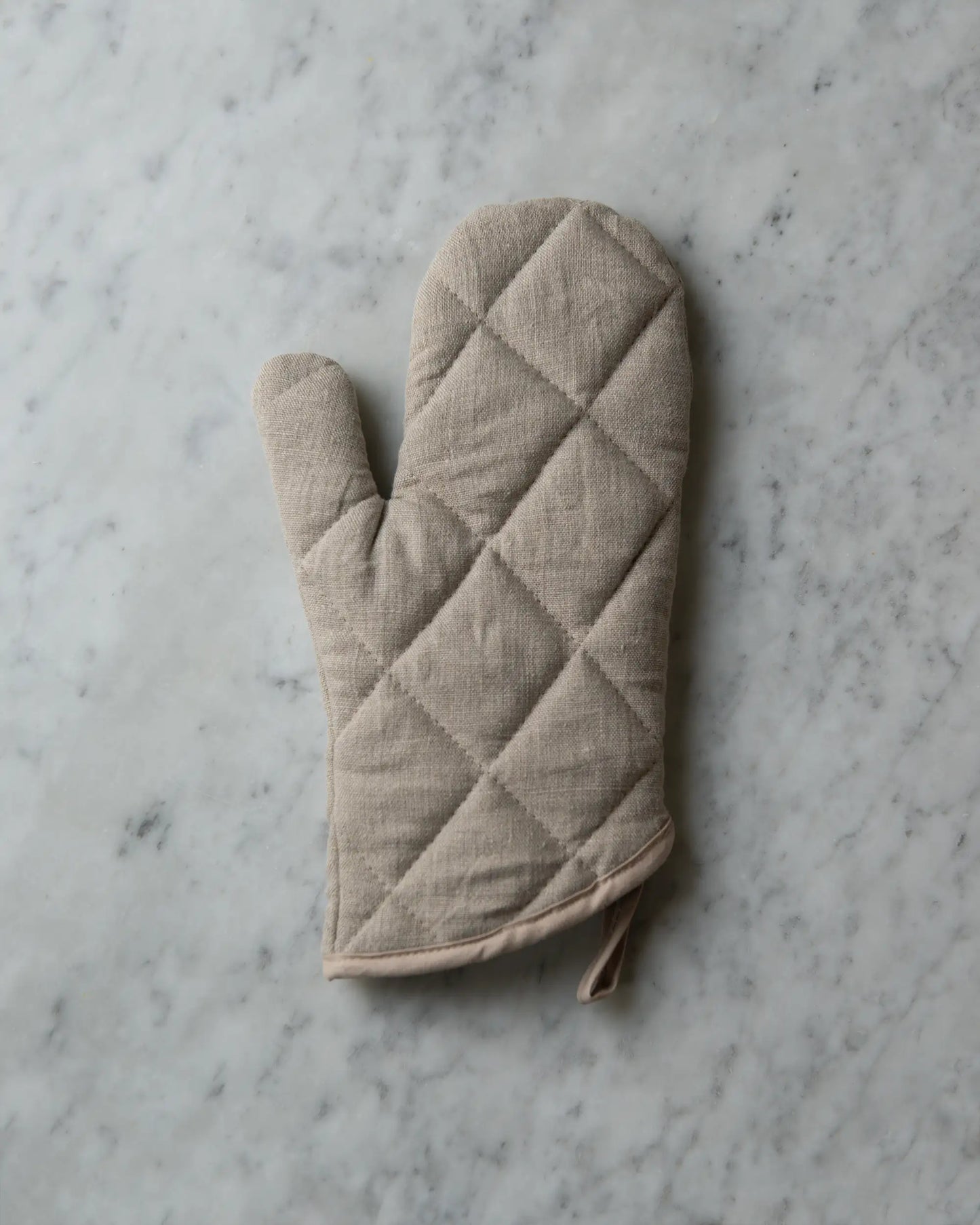 En handsydd beige grytvante i linne.
