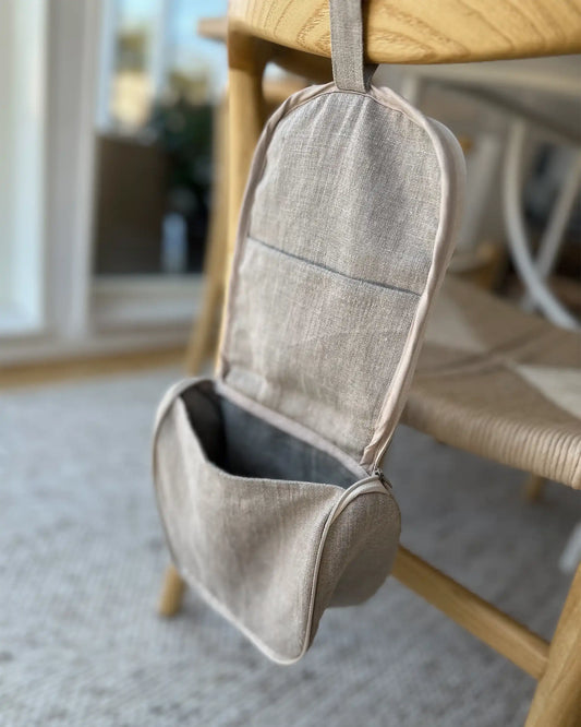 En handsydd linnenecessär med dragkedja och ögla för upphängning.