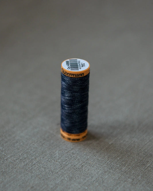 Trådrulle i mörkblå för lagning av jeans.