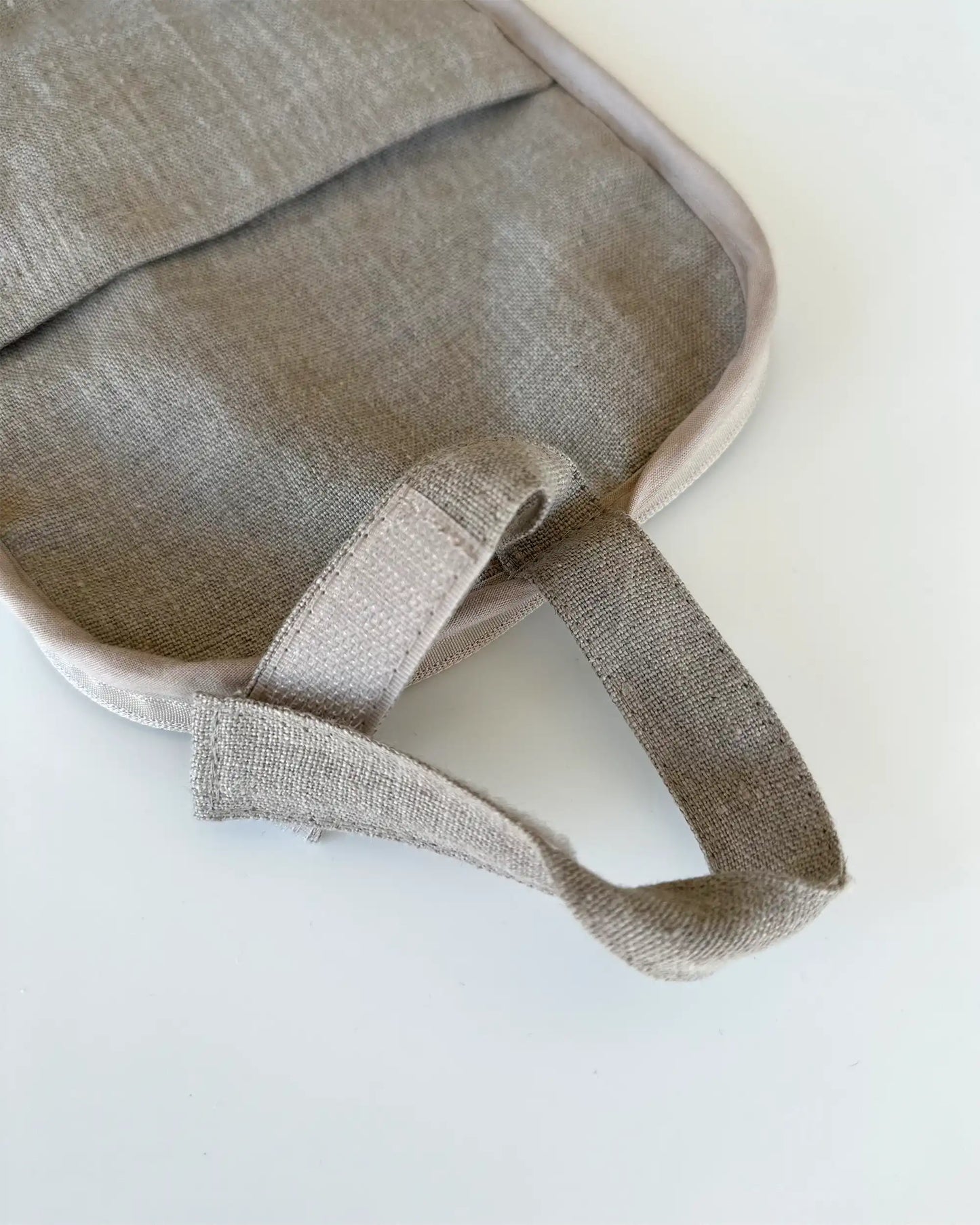 En handsydd sminkväska i stentvättat linnetyg med ögla för upphängning och kardborreband