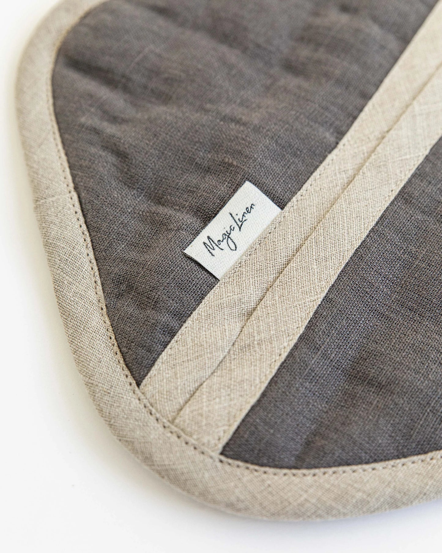 Enkel grytlapp i linne som är inzomad och visar linets struktur. Varumärkets logga framträder och där står det Magic Linen. 