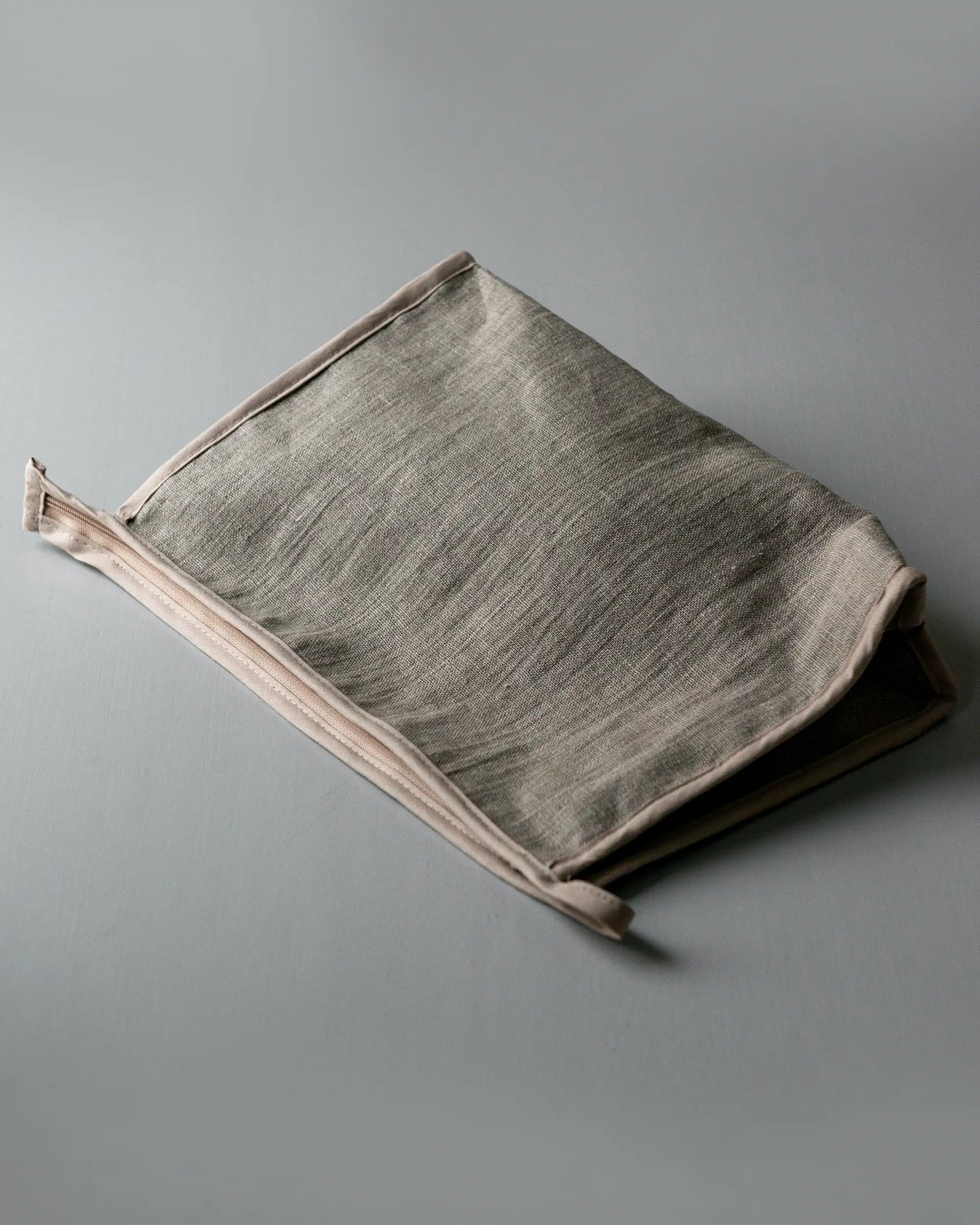 En handsydd beige necessär i linne med dragkedja.