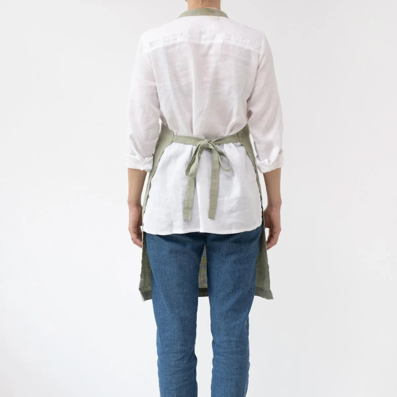 Ett linneförkläde i ljusgrönt med band.