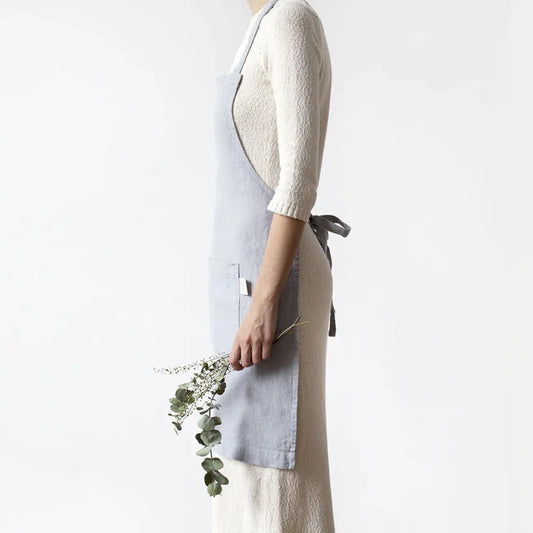 Ett handsytt ljusgrått förkläde i linne.