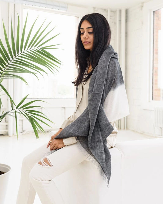 En handvävd grå och vit linnesjal med fransar.