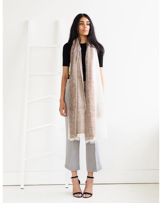 En handvävd linnesjal med fransar i brun och beige.