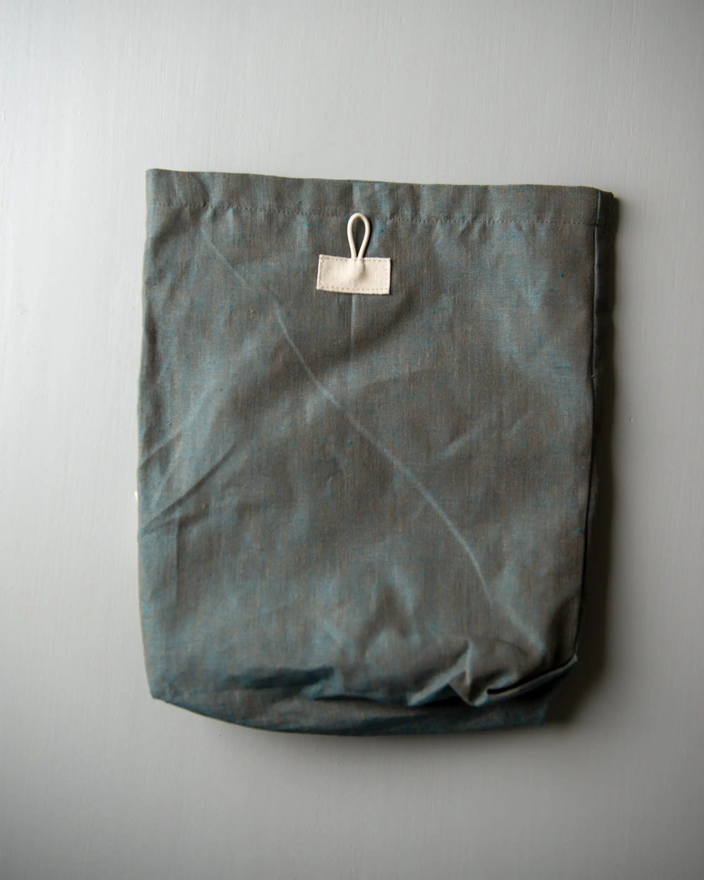 En grön handsydd förvaringspåse i linne.