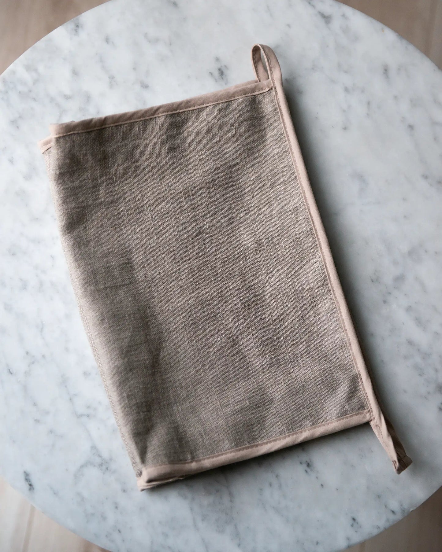 En handsydd beige linnenecessär med dragkedja.