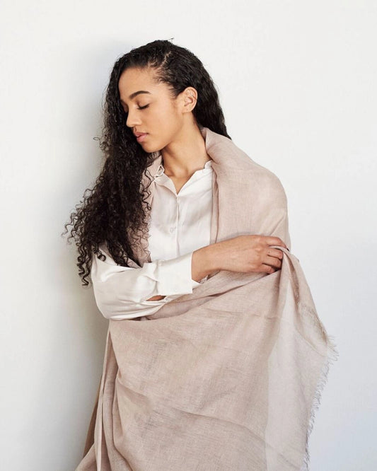 En stor handvävd linnesjal med fransar i beige.